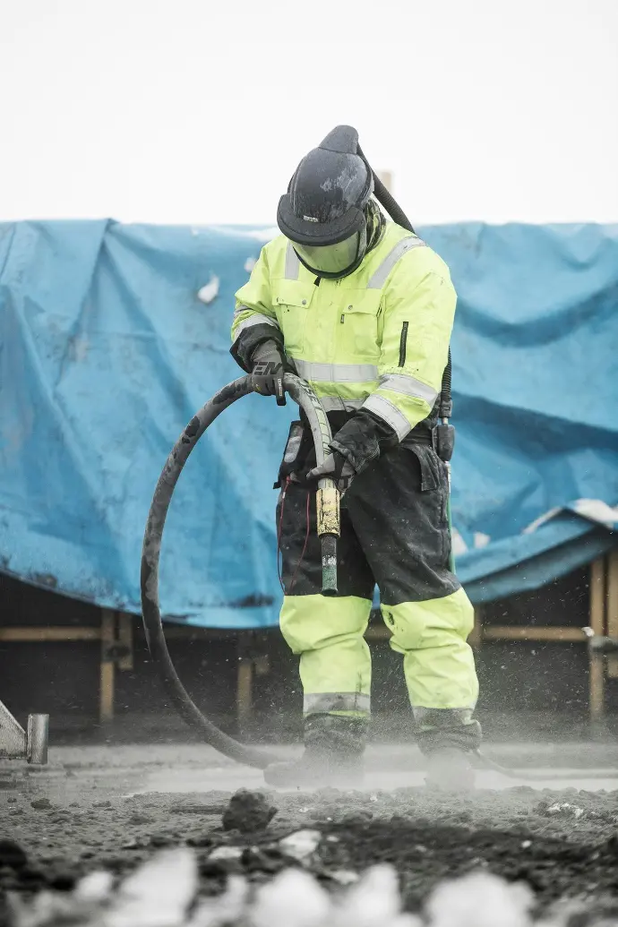 a man in a yellow uniform is using a hose